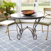 Cleo Navy Indoor/Outdoor Rug styled under metal patio furniture. Styled view. 