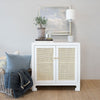 Colette Occasional Cabinet styled with decor and a lamp and blue bedding. Styled view.