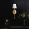 Auburn Crystal Sconce styled on a black wall with books and greenery. Styled view.