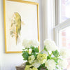 Crowned Parakeet styled with florals beside a window. Styled view.