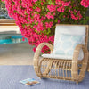 Diamond Denim/White Indoor/Outdoor Rug styled outdoors with a wicker chair and pink florals. Styled view. 