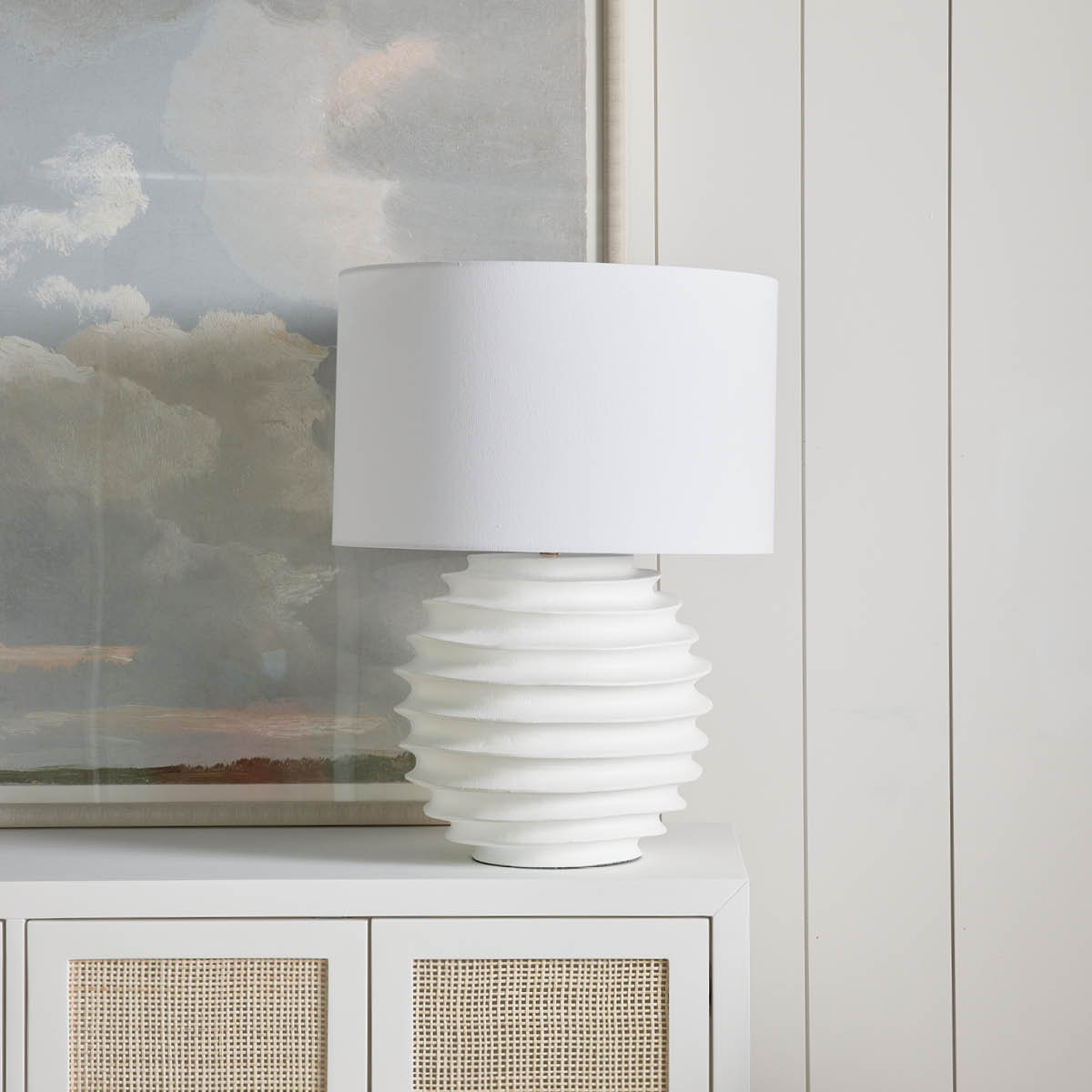 Eaton Metal Table Lamp styled on a white side table with artwork. Styled view.