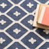 Elizabeth Navy Indoor/Outdoor Rug styled underneath books. Styled view. 
