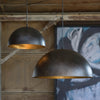 Flynn Pendant - Small Black & Gold styled in a rustic barn with artwork. Styled view.