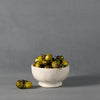 Footed Marble Bowl - Small Marble styled with green ornaments on grey. Styled view. 