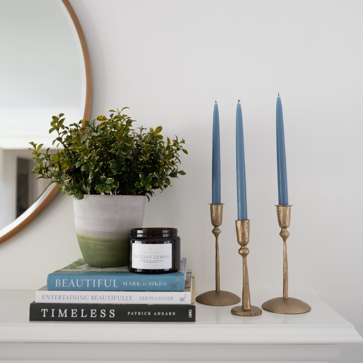 Hand-Dipped Danish Tapers - Blue/Grey styled with gold candle sticks and books. Styled view.
