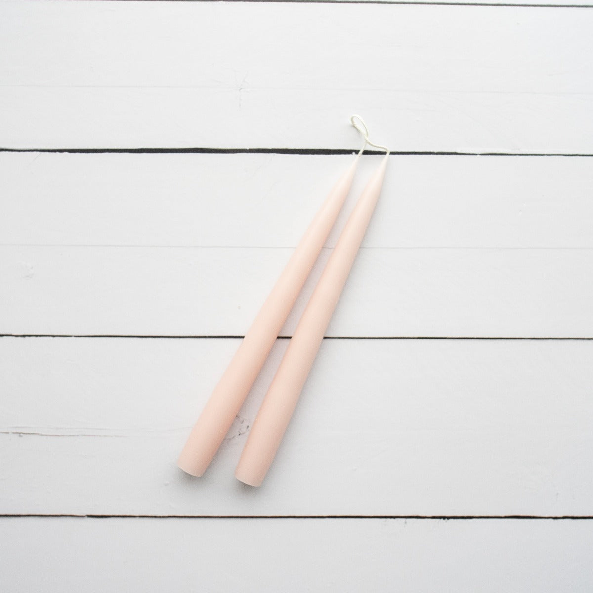 Hand-Dipped Danish Tapers - Soft Pink styled on white wood. Styled view.