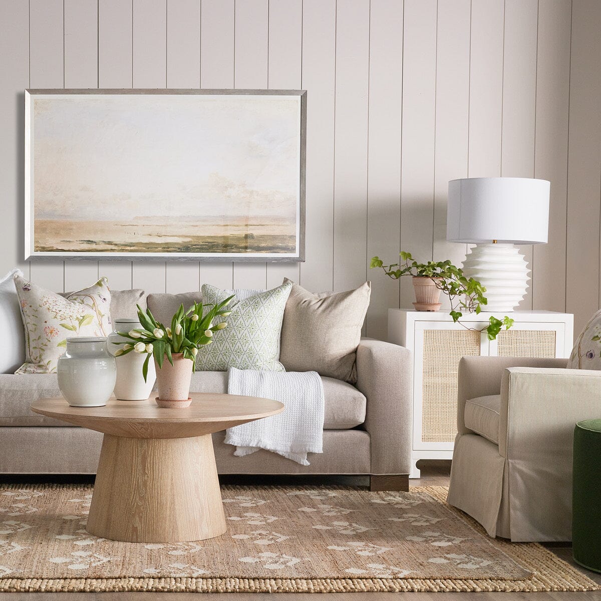 Henry Sofa styled with artwork, throw pillows and neutral, accent chair. Styled view.
