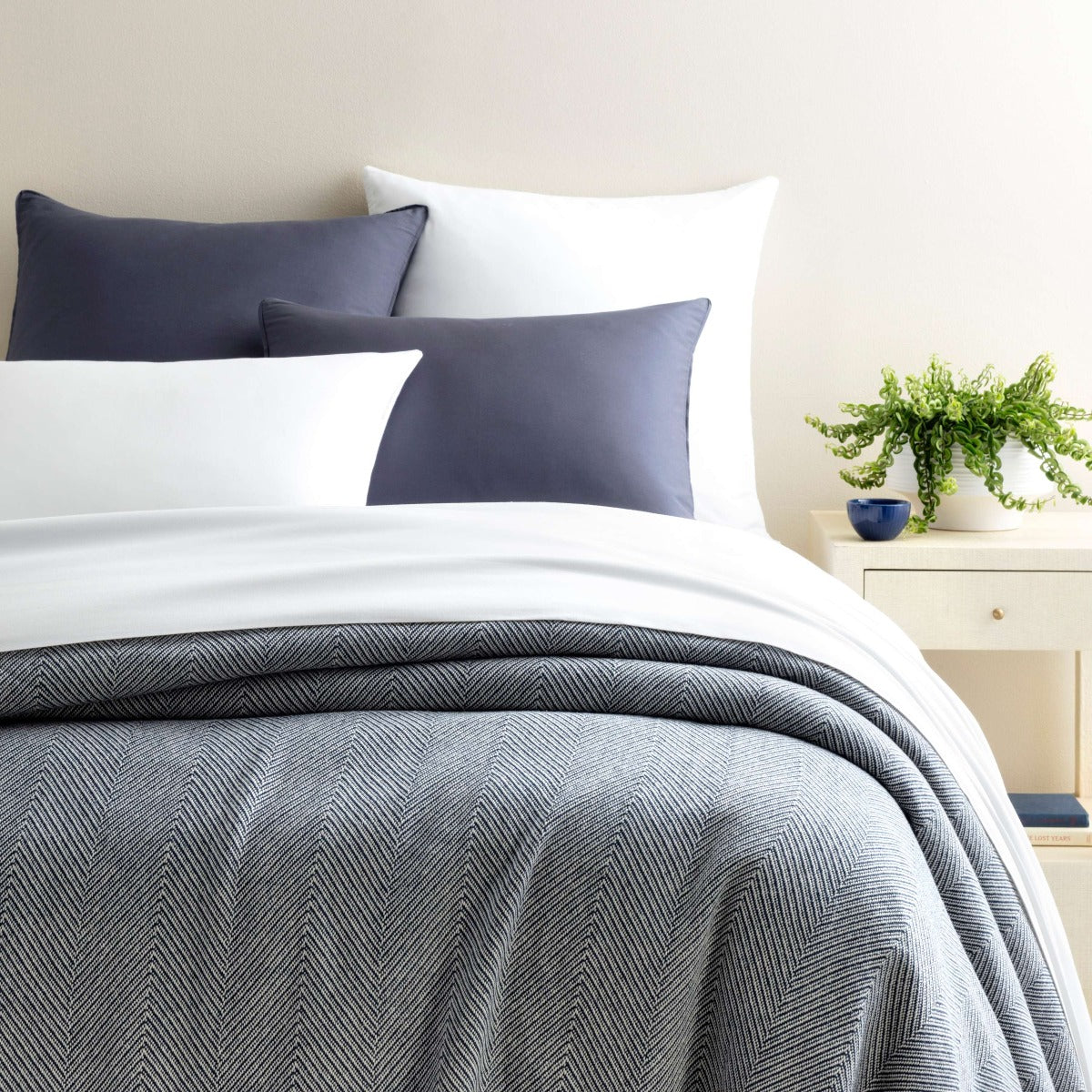 Herringbone Navy/Ivory Blanket styled with white and navy bedding. Styled view. 