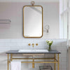 Hudson Mirror styled above a sink with golden fixtures. Styled view. 