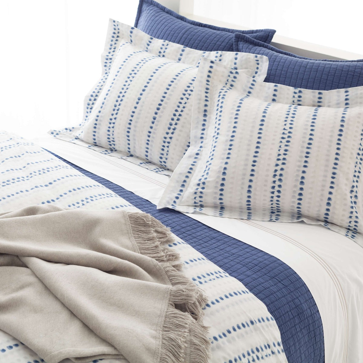 Ink Dots Duvet Cover styled with navy sheets. Styled view. 