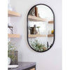 Josie Mirror Steel styled on a white wall with wood shelves. Styled view. 