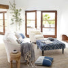 Jute Woven Seaglass Rug styled in a neutral and blue living room. Styled view. 