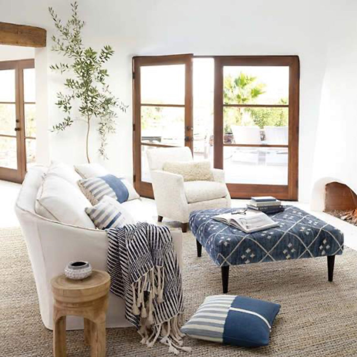 Jute Woven Seaglass Rug styled in a neutral and blue living room. Styled view. 