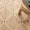 Kali Woven Jute Rug styled with a wood stool. Styled view. 