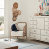 Kinsley Accent Chair styled with a blue throw beside a dresser with wall art. Styled view.