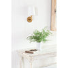 Legend Single Sconce styled over a white table with greenery. Styled view.