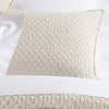 Lodi Alabaster Matelasse Sham styled with white sheets. Styled view.