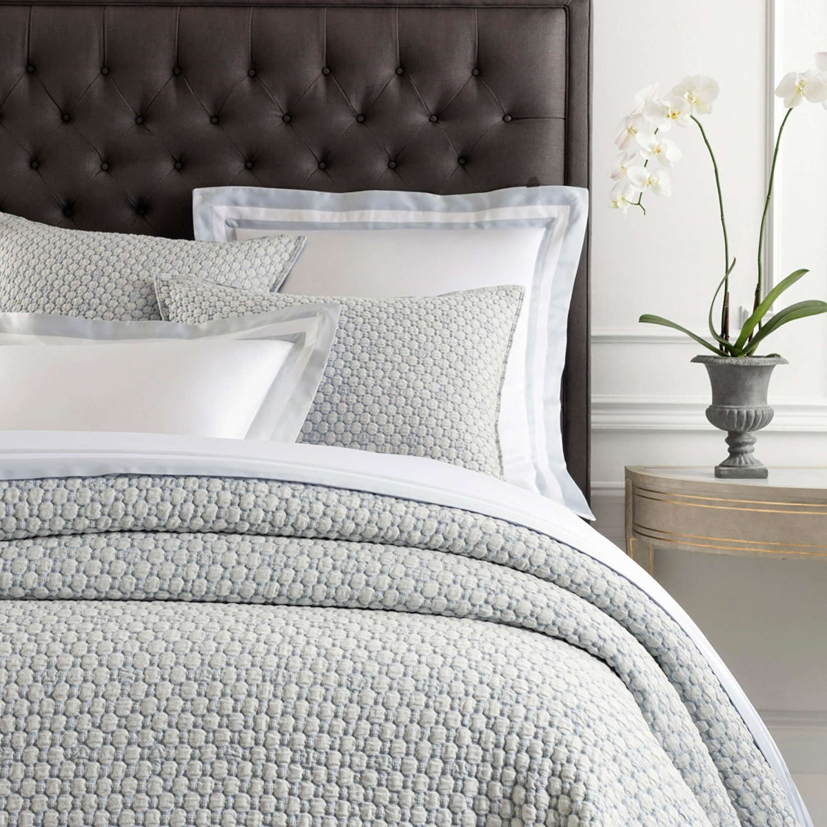 Lodi Blue Matelasse Coverlet styled with grey and white bedding. Styled view. 