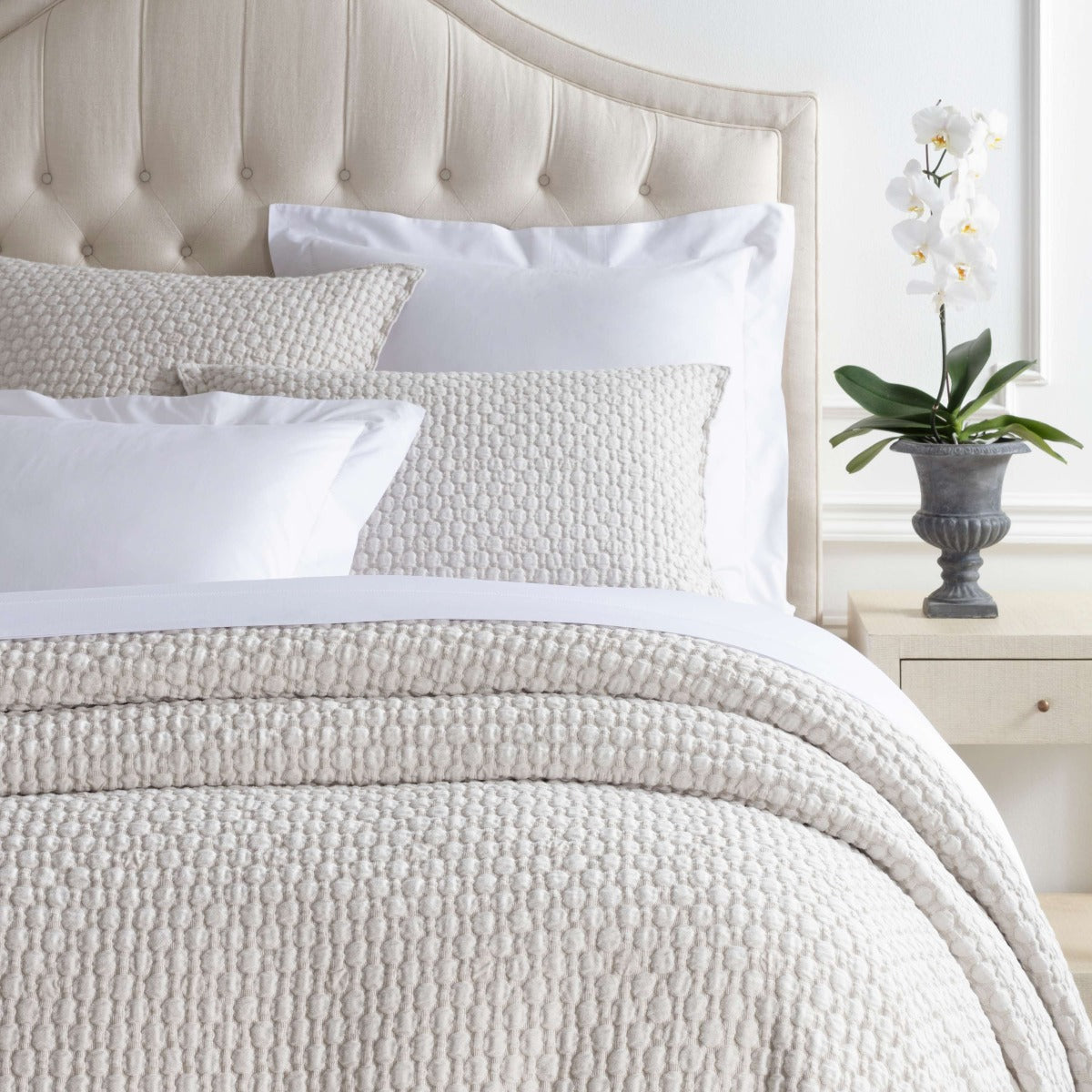Lodi Sand Matelasse Coverlet styled with white sheets. Styled view. 
