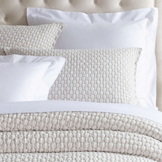 Lodi Sand Matelasse Sham styled with white sheets. Styled view. 