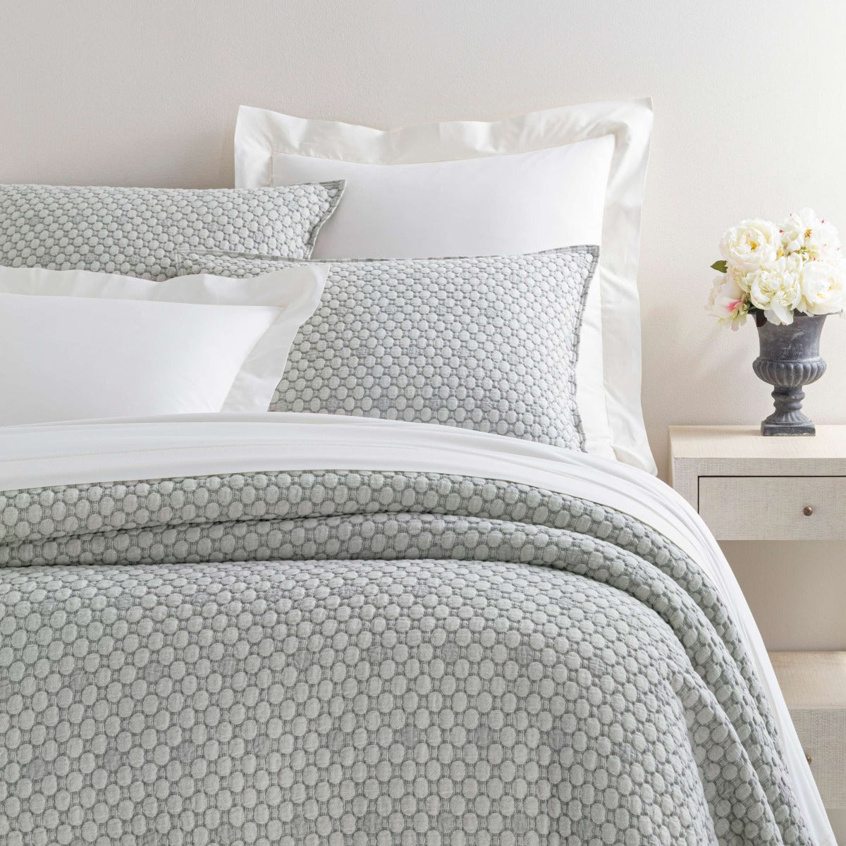Lodi Silver Matelasse Coverlet styled with white sheets. Styled view. 