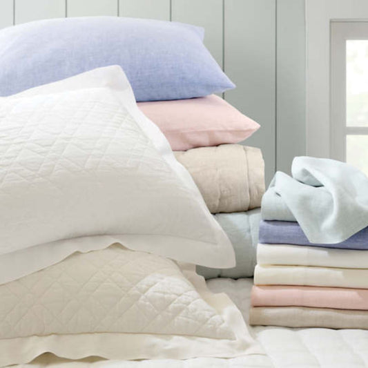 Lush linen bedding in a variety of colours. Styled view.