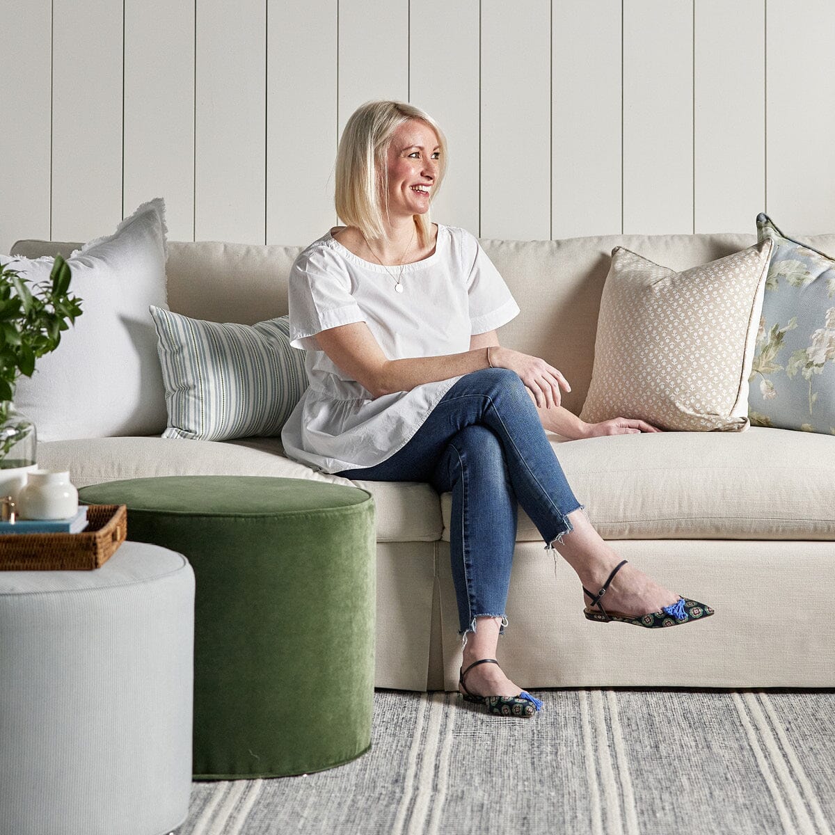 Margot Sofa styled with pillows, ottomans and spring decor. Styled view.