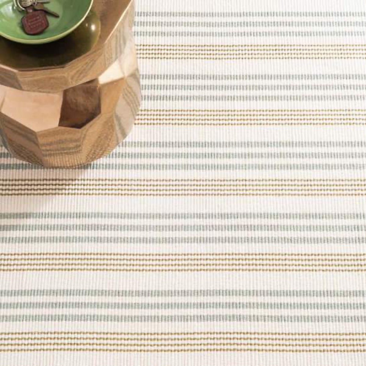 Olive Branch Woven Cotton Rug styled under a wood table. Styled view. 