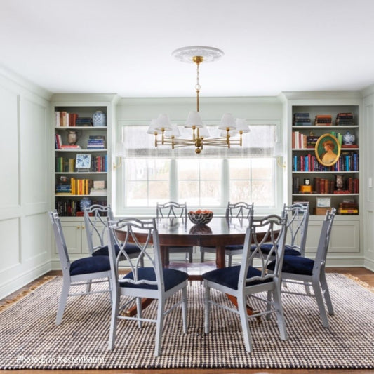 Oxford Brass Chandelier styled over a dining table with blue chairs. Styled view.