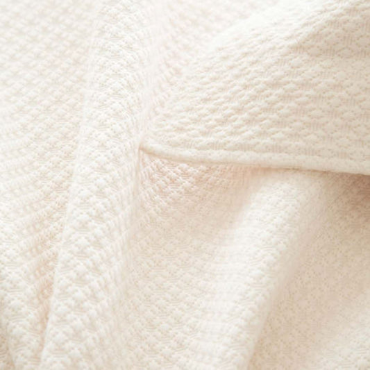 Close up of matelasse coverlet. Close-up detail view.