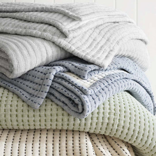 Pitch stick bedding in green, grey, blue and cream. Styled view.