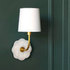 Robin Bent Arm Sconce styled on a green panel wall. Styled view.