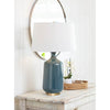 Rowen Mirror styled above a distressed table with blue lamp and decor. Styled view.