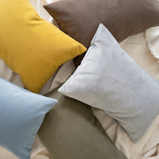 Royal Velvet Lumbar Pillow - Dove Grey styled in a pile of velvet pillows. Styled view. 
