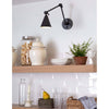 Sal Task Sconce Oil Rubbed Bronze styled over open kitchen shelving. Styled view.
