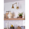 Sal Task Sconce Natural Brass styled over open kitchen shelving. Styled view.