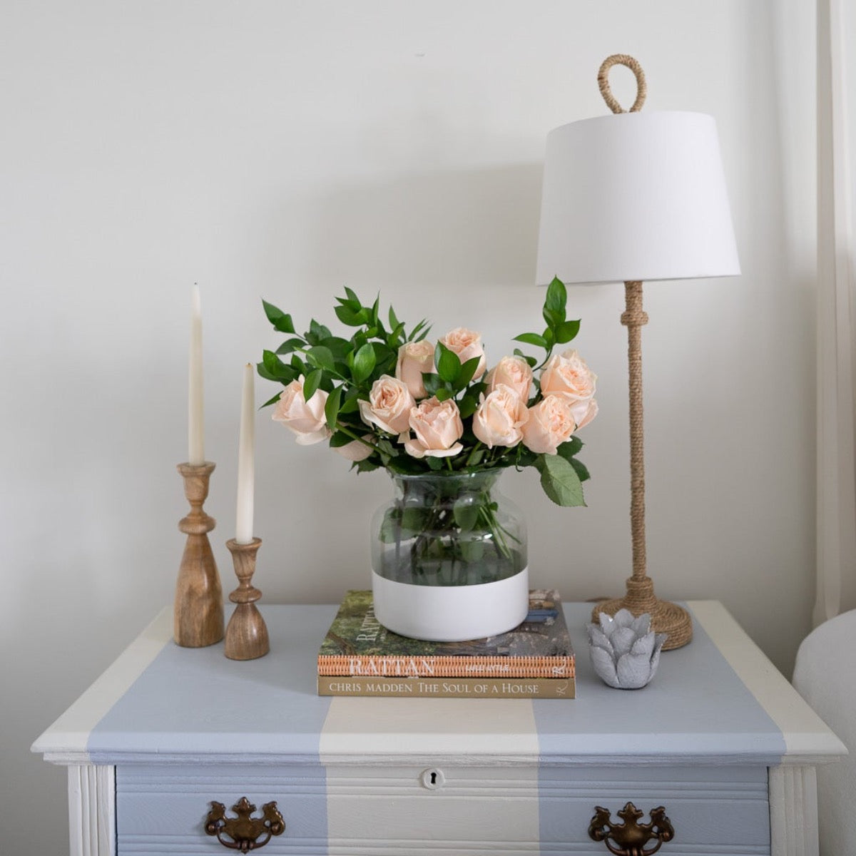 Bimini Buffet Lamp styled on a blue and white side table with greenery. Styled view.