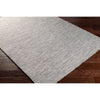 Seattle Grey Outdoor Rug styled over dark wood. Styled view.