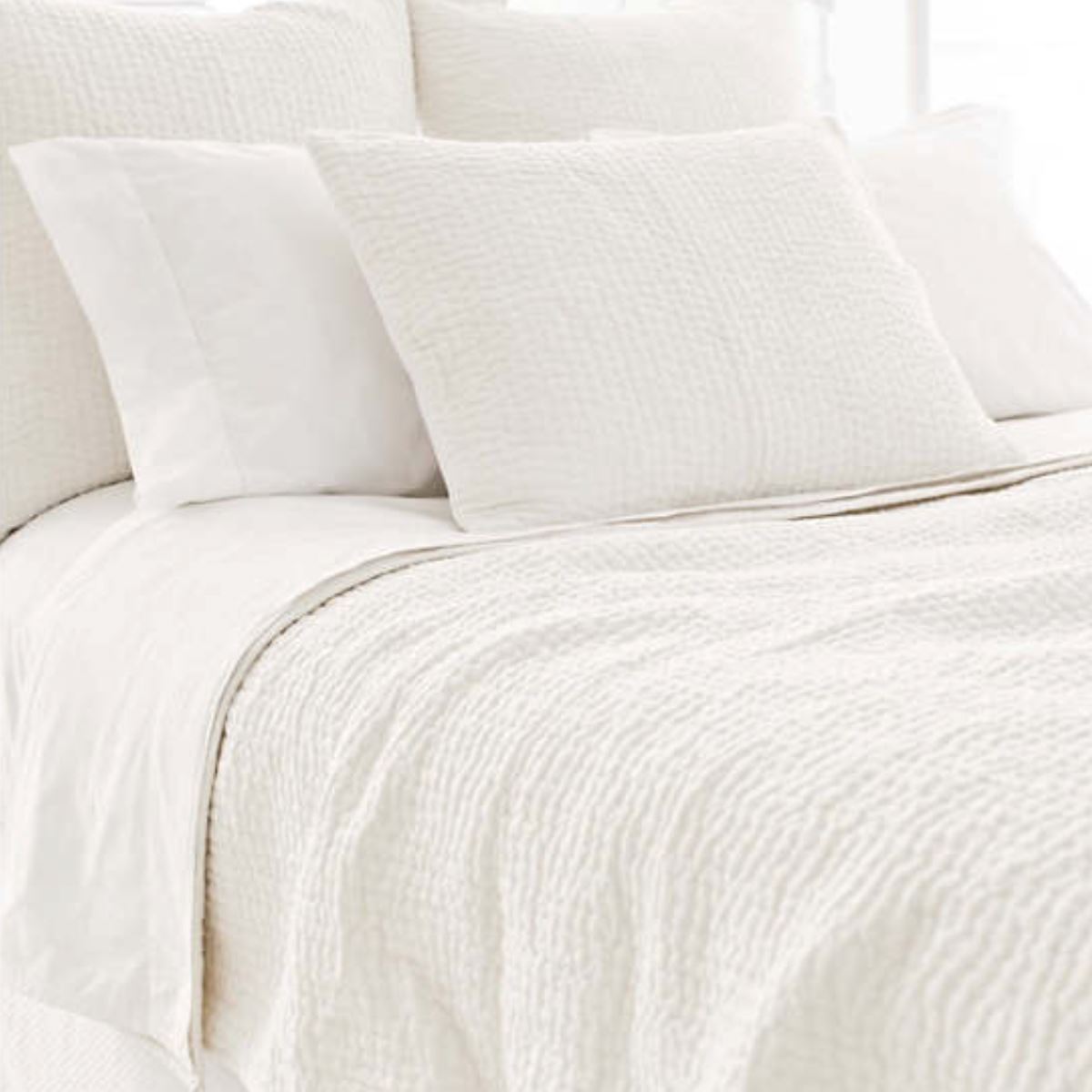 Seychelles Dove White Quilt styled with white sheets. Styled view. 