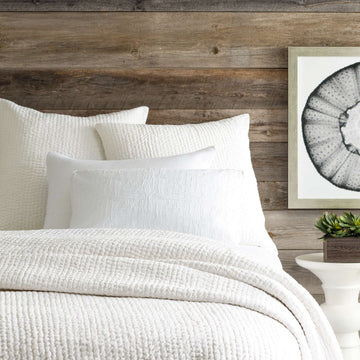 Seychelles Dove White Quilt styled with white sheets. Styled view. 
