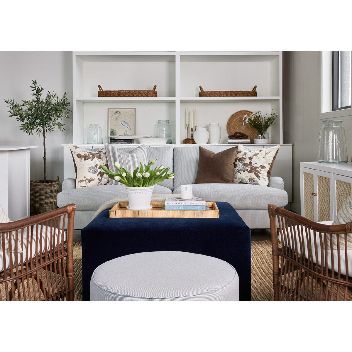 Stephen Sofa styled with brown and blue decor in a neutral living room. Styled view. 