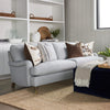 Stephen Sofa styled with blue and brown throw pillows and a navy ottoman. Styled view. 