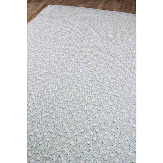 Swiss Dot Rug - Sky Blue over wood floor. Styled view. 