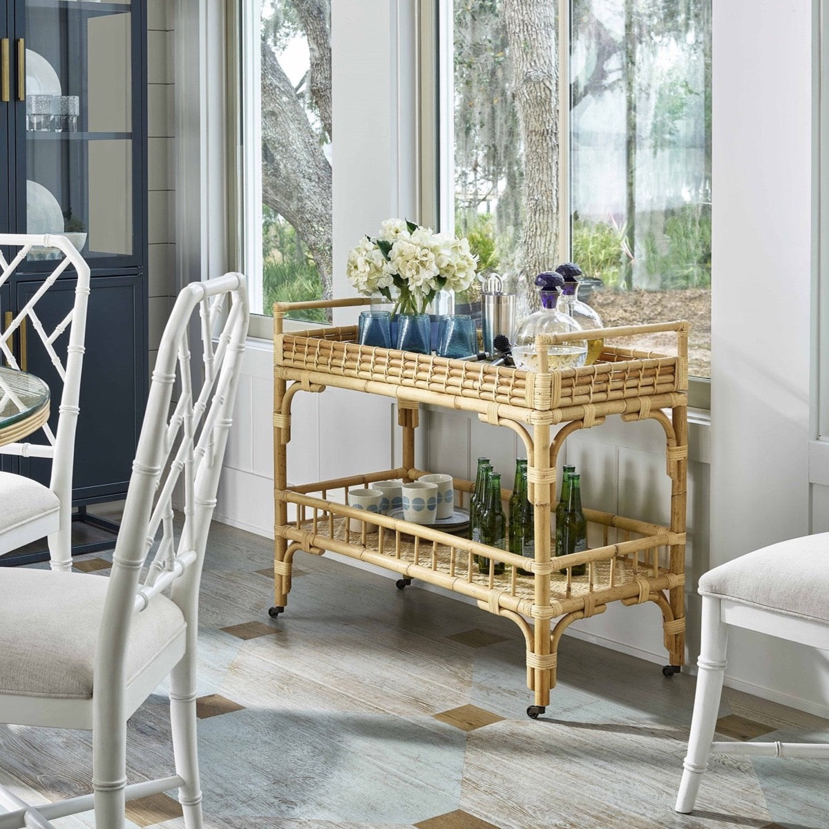 Tanner Rattan Bar Cart styled with florals and decorative glasses. Styled view.