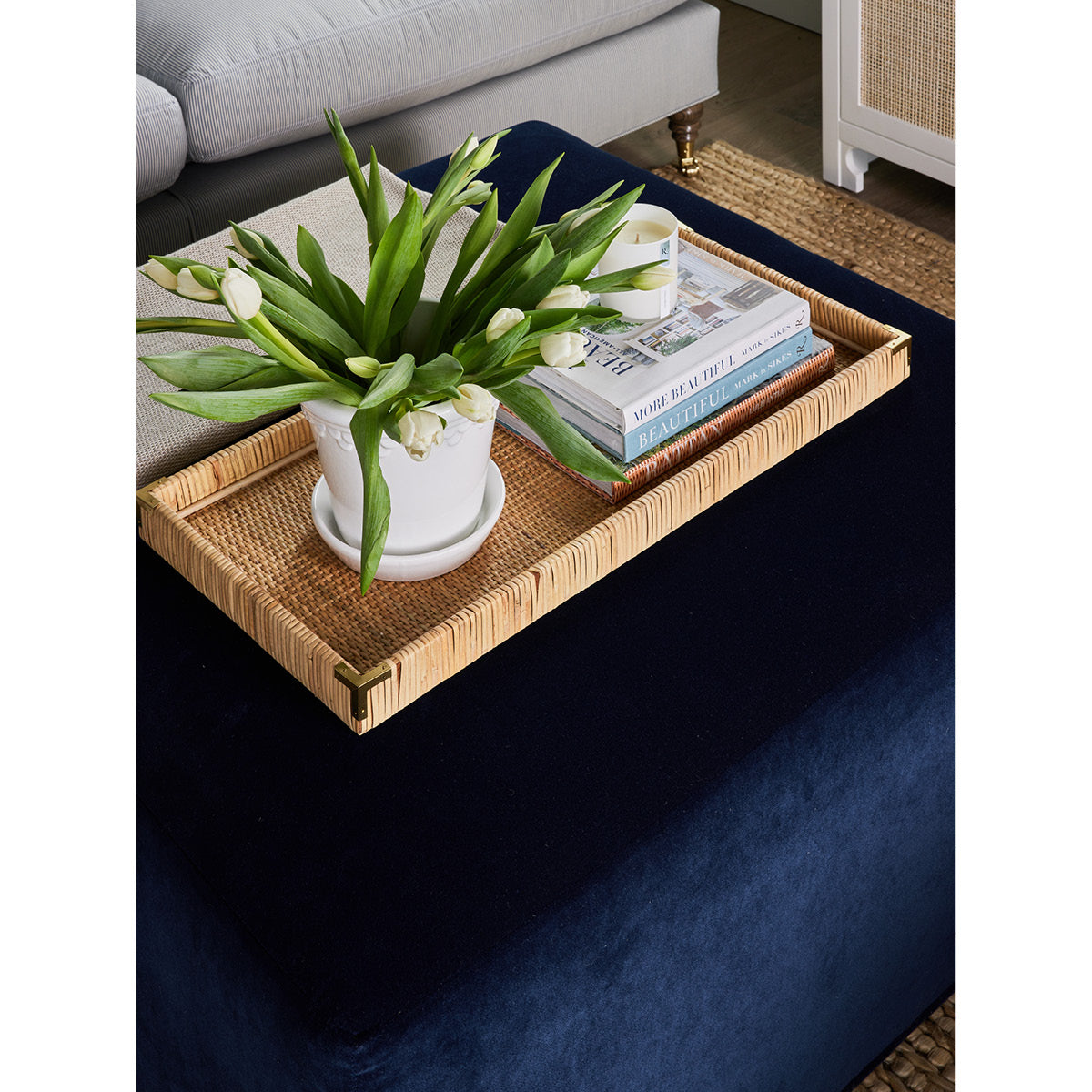 Thomas Block Ottoman styled with rattan tray and coffee table decor. Styled view. 