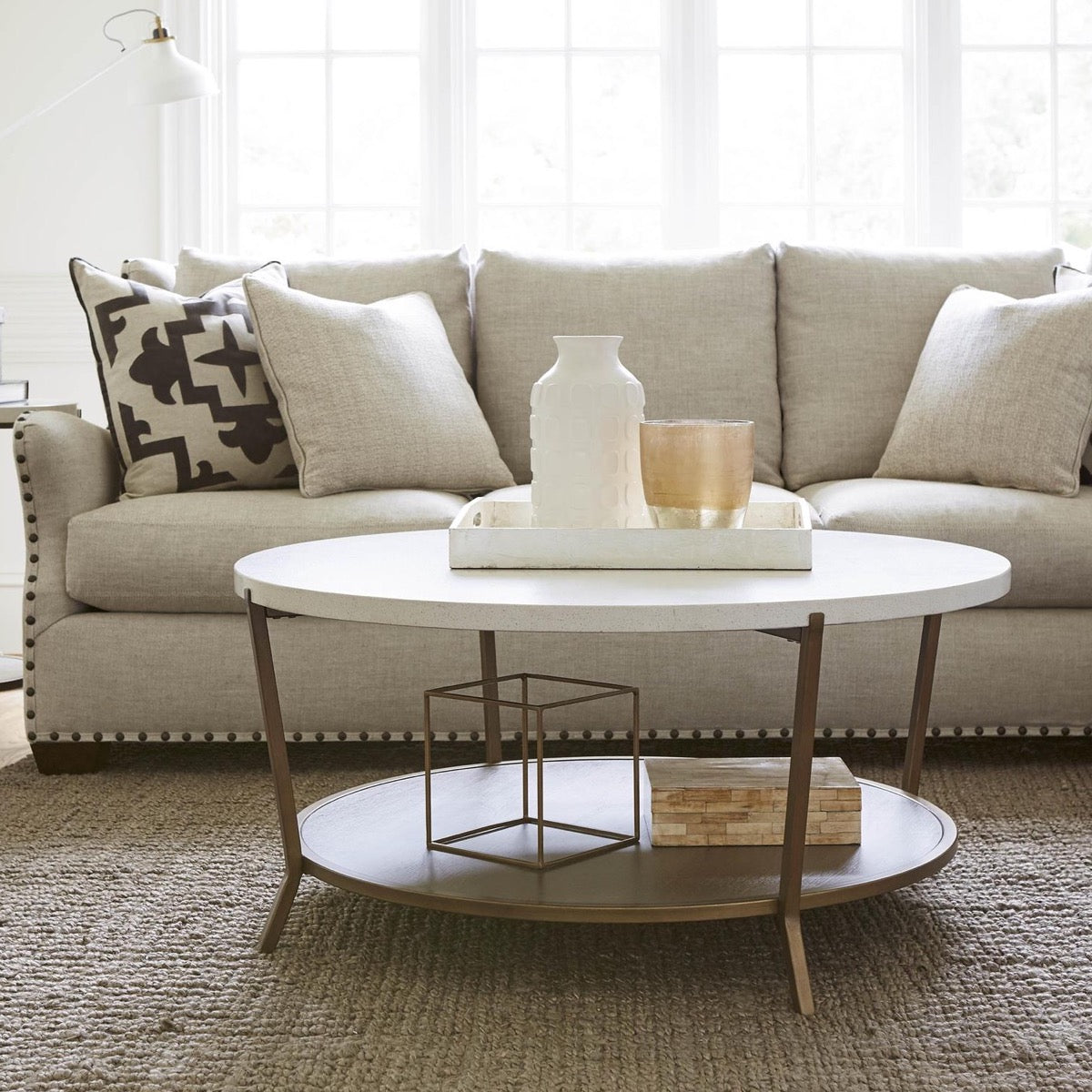 Tilley Coffee Table styled with a tray, metal decor and wood box beside a neutral grey sofa. Styled view.