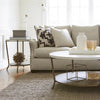 Tilley End Table styled with decorative gold ball, storage boxes and book beside a grey sofa. Styled view.