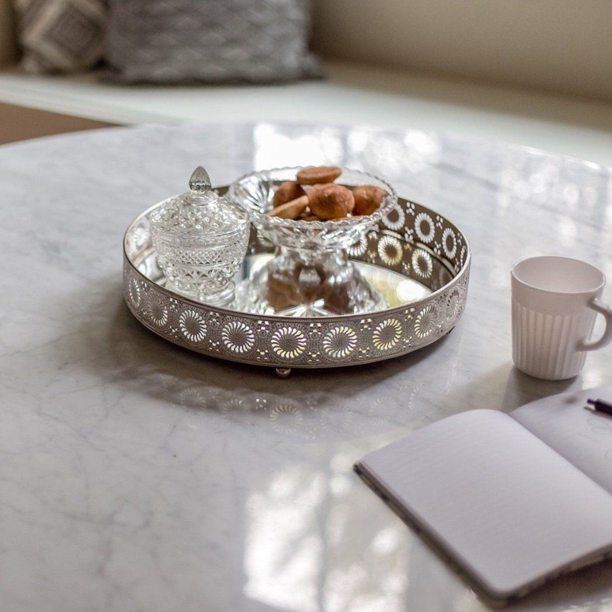 Trumpet Dining Table Round - Condo Size styled with a metal tray. Styled view.