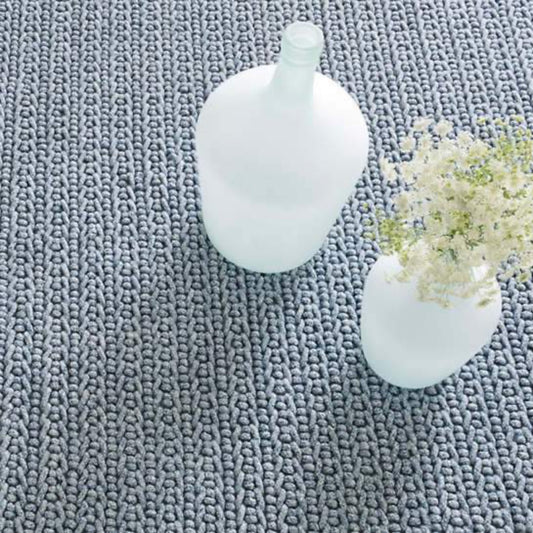 Veranda Denim Indoor/Outdoor Rug styled under white vases. Styled view. 